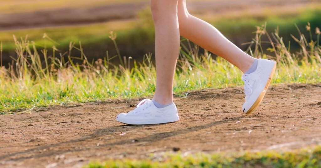 best walking shoes for women over 50 worn outdoors on a sunny path