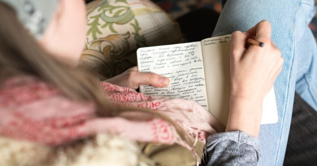Woman journaling a perimenopause symptoms checklist in a notebook at home